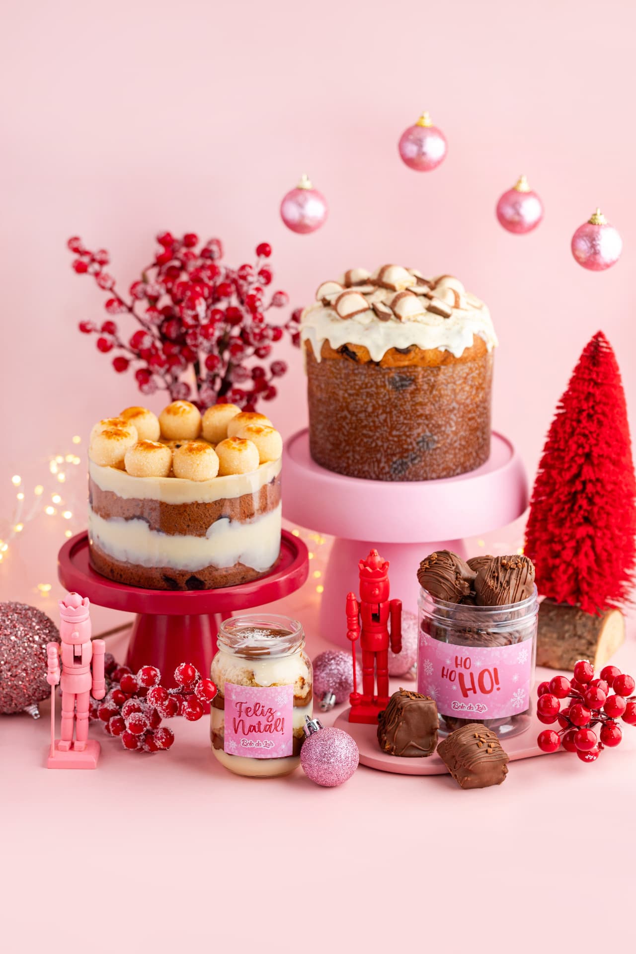 Chocotones e doces natalinos em cenário rosa